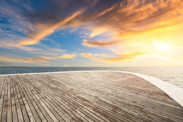 istock Wood square and dramatic sky with coastline at sunset 1061950004