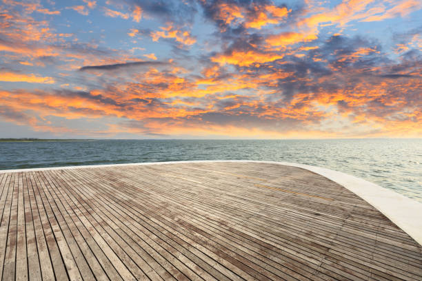 istock Wood square and dramatic sky with coastline at sunset 1061950268