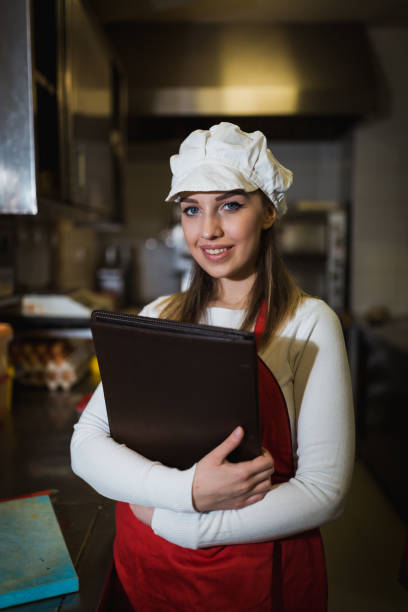 istock Young woman working in the restaurant and holding a menu 1061951512