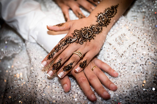 view on the hand of the fresh wife and her husband. Nice henna tatoo on the hand
