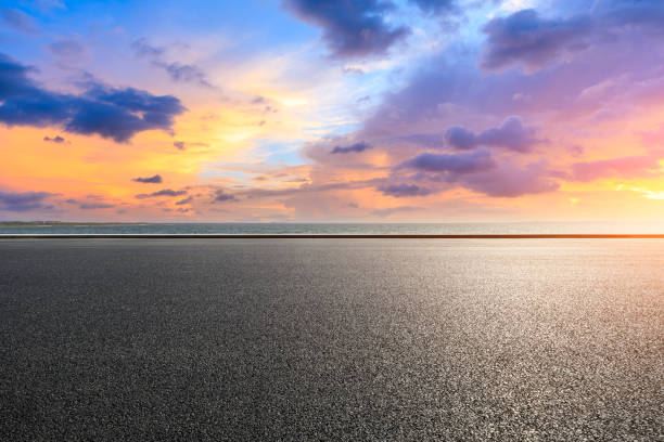 istock Asphalt road and dramatic sky with coastline at sunset 1061955214