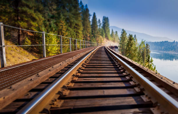 Train tressle A close-up, tilt-shift view of a train trestle that rounds a curve and slowly vanishes into the distance tressle stock pictures, royalty-free photos & images