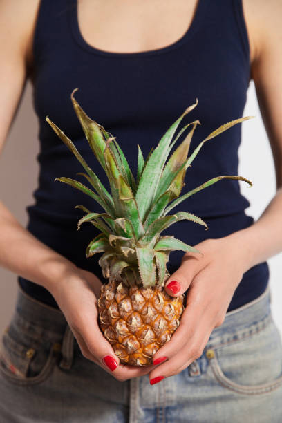 istock Young woman holding pineapple on her hand 1061988984