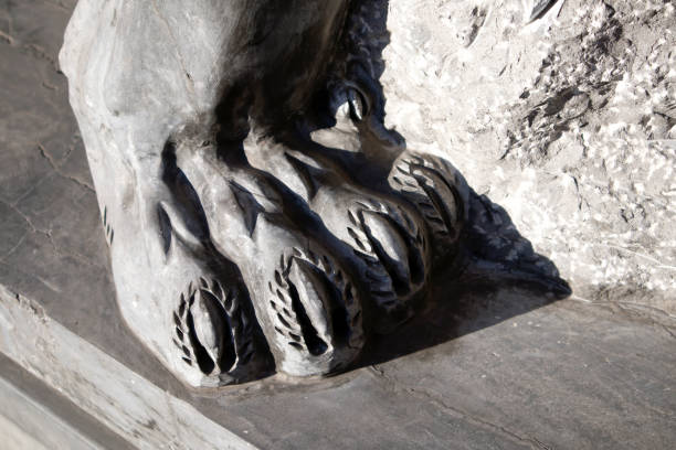 istock Hind paw of grey granite lion statue closeup 1061990530