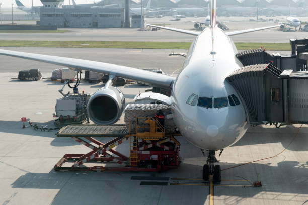 Loading cargo on plane in airport before flight. Foreman control loading Containers box to cargo plane. stock photo