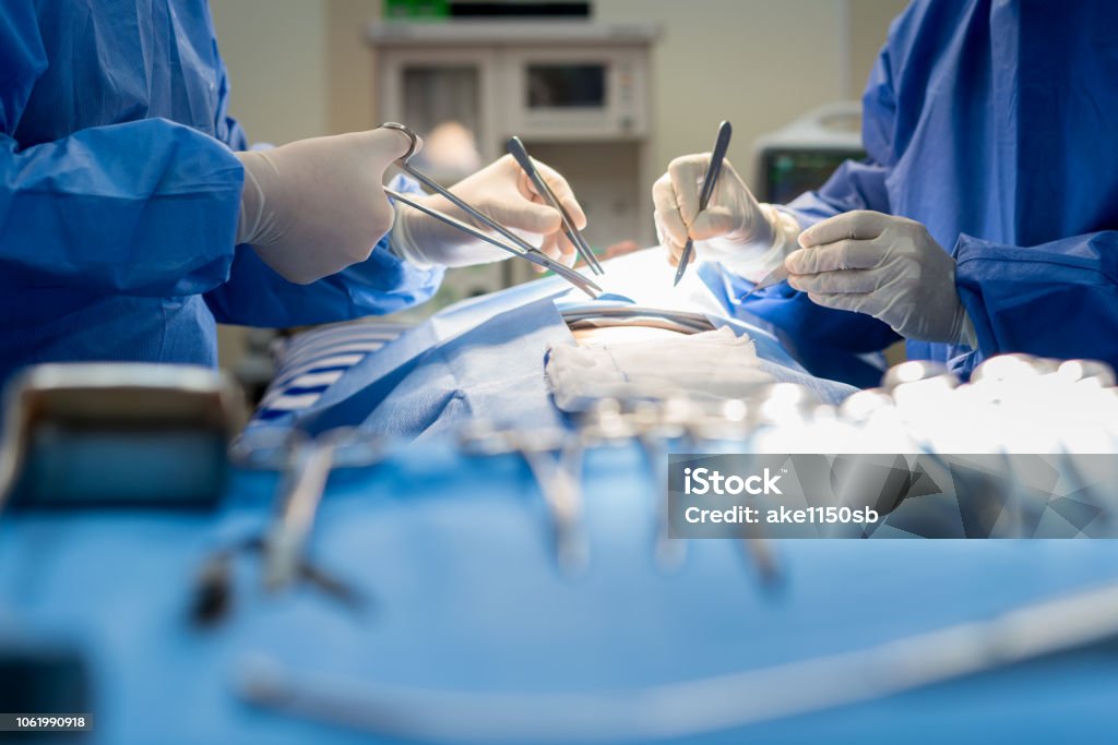 Asian doctor and an assistant in the operating room for surgical venous vascular surgery clinic in hospital. Surgery Stock Photo