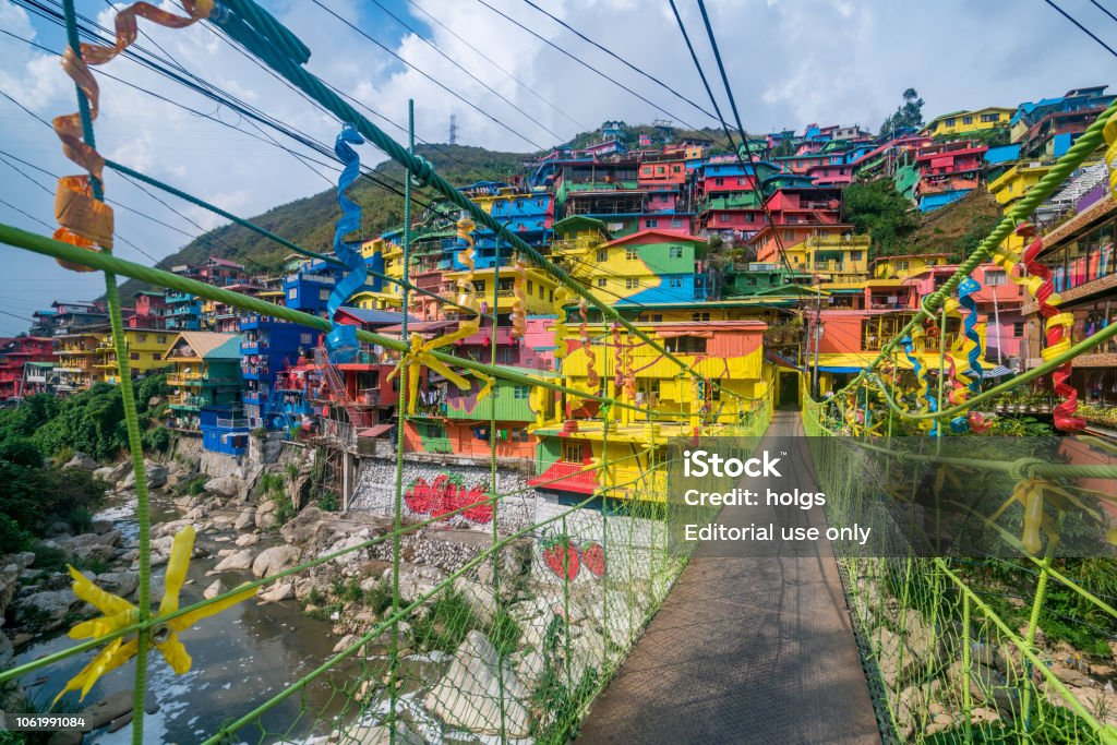 Hanging bridge connecting to Stobosa Mural a Valley of colors in La Trinidad, Benguet, Baguio City Baguio, Philippines - May 2, 2017: Baguio  view showing hanging bridge connecting to Stobosa Mural a Valley of colors in La Trinidad, Benguet, houses with bright colors, river, rocks, mountains and trees can be seen on the background Philippines Stock Photo