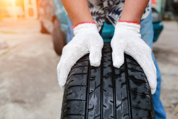 istock Mechanic hands change a car tyre on street 1062001154