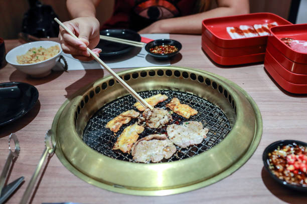 istock woman hands roasting korean barbecue meat with chopstick 1062001188