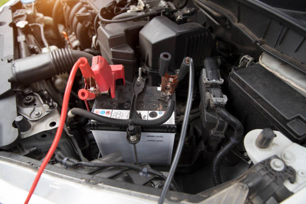 istock Mechanic charging old car with electricity trough jumper cables 1062001216