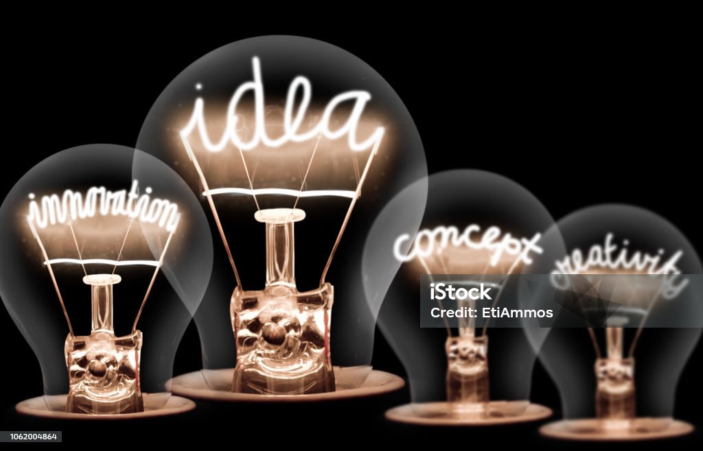 Light Bulbs Concept Photo of light bulbs with shining fibres in IDEA, VISION, CONCEPT and CREATIVITY shape on black background Creativity Stock Photo