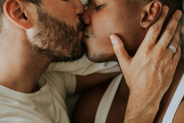 apasionada pareja gay haciendo hacia fuera - gay man homosexual men kissing fotografías e imágenes de stock