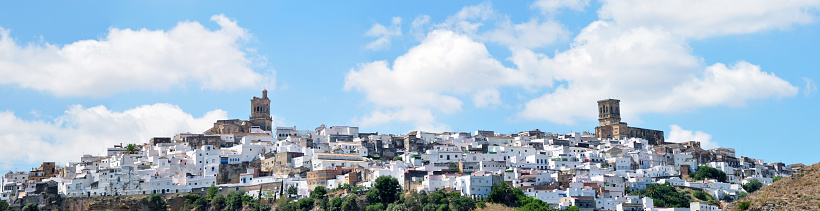 Blue sky and white clouds on the Church of Arcos de la Frontera in a hillside