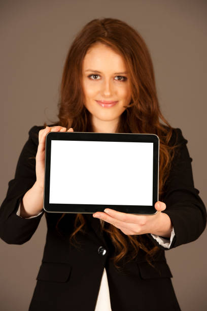 istock attractive business woman holds a tablet or smartphone wtih blank copy space for additional graphic or text 1062032958