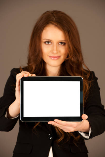 istock attractive business woman holds a tablet or smartphone wtih blank copy space for additional graphic or text 1062032978