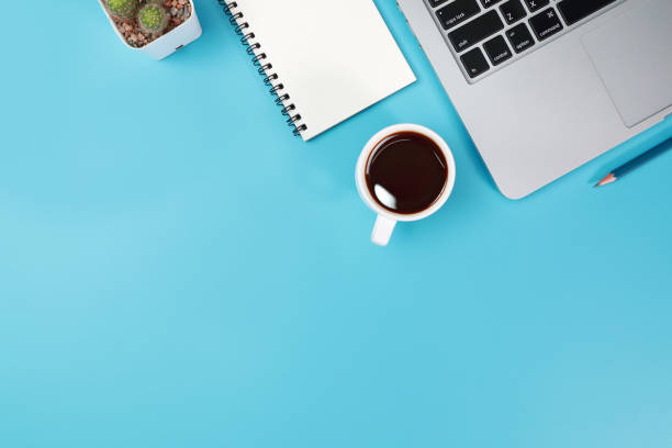 istock business office table with workspace, laptop computer, coffee cup, notebook, pencil, plant and cell phone on blue pastel background 1062033256