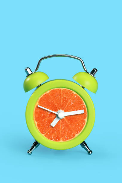 istock orange in time clock on blue pastel desk 1062033492