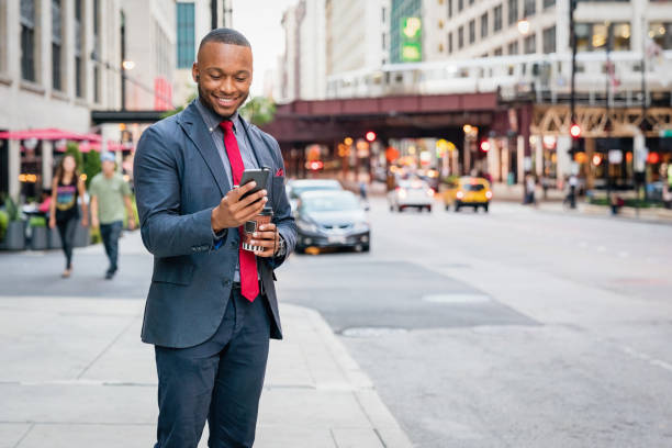 istock Happy Businessman reading messages on his mobile phone in Chicago 1062037446