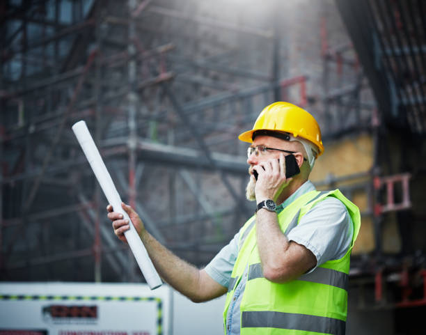 istock Mature male construction professional in hard hat talks on phone 1062037606