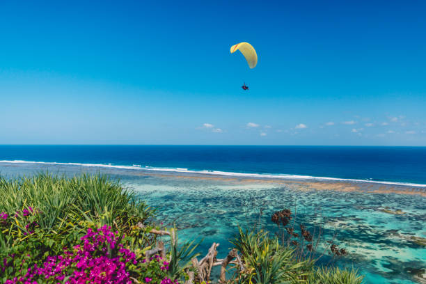 istock Shore and blue ocean with paraglider in tropical island. 1062046178