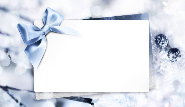 Silver gift boxes with blue and gold ribbons placed near blank white banner isolated on white background. Copy space for greeting, holiday card, or advertisement design.