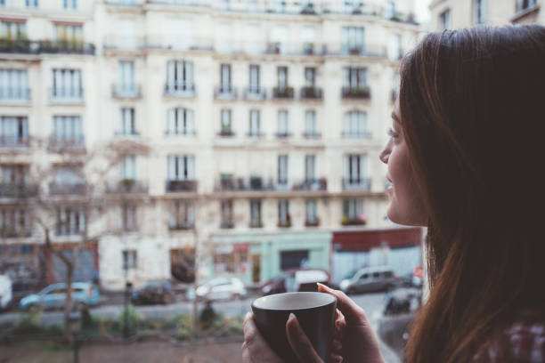 istock Relaxed woman drinking coffee at the window 1062062168