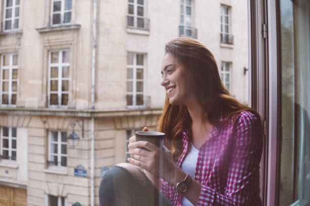 istock Relaxed woman drinking coffee at the window 1062062182