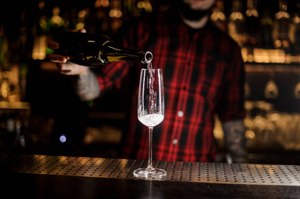 istock Professional bartender pouring a champagne from a bottle to a glass 1062064172