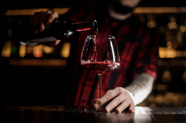 istock Professional bartender pouring a delicious wine from a bottle to a glass 1062064286