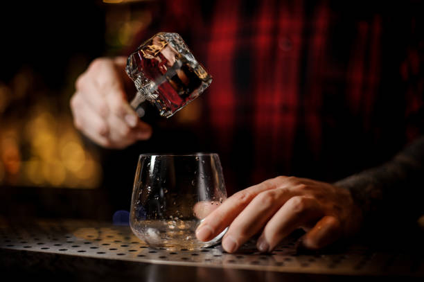 istock Bartender putting the ice cube to a glass preparing a James Cook cocktail 1062065370