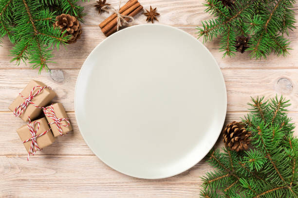 istock Empty white matte plate on wooden background with christmas decoration, Round dish. New Year concept 1062065384