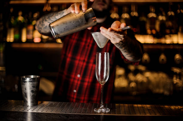 istock Professional bartender pouring a cocktail from a shaker to a glass 1062066714