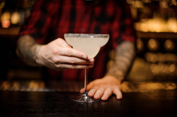 istock Bartender serving Margarita cocktail in the glass decorated with sugar 1062066870
