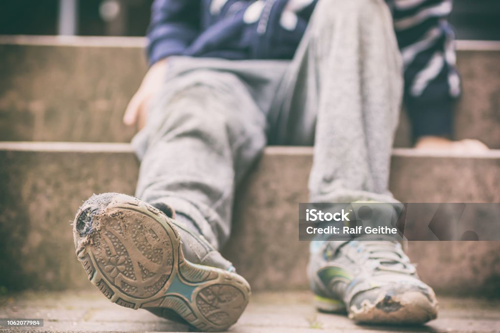 Old broken shoes of a little boy as a symbol for child poverty child poverty Poverty Stock Photo