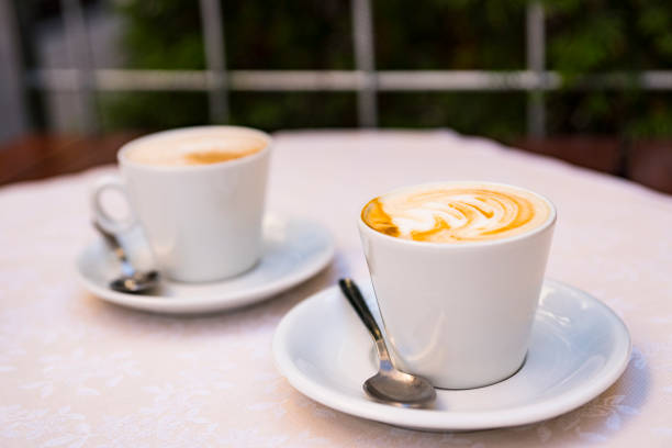 istock two white cup and saucer with cappuccino 1062079824