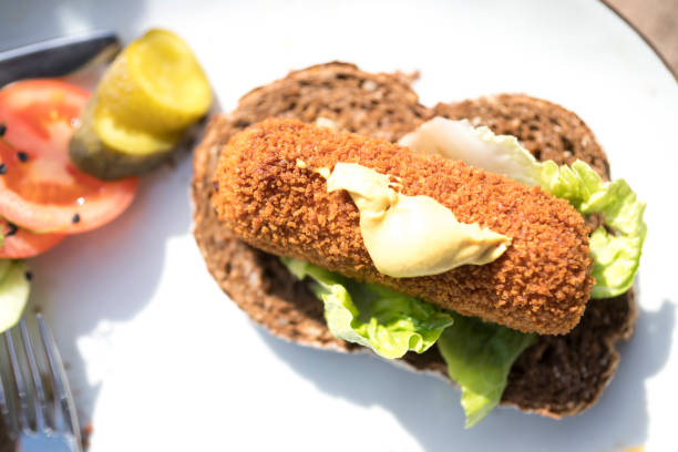 istock plate with typical Dutch meal, fired snack croquet with salad on slice of bread 1062080252