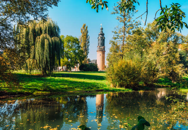 Weimar, Thuringia, Germany - Oktober 10, 2018: View in autumn of the lawns of Park an der Ilm and the bastille tower. Both the park and the City Castle are part of the World Heritage Site.