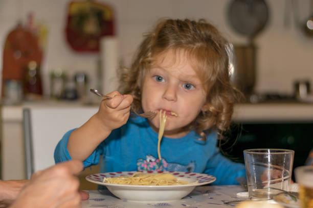 istock Little girl eating spaghetti 1062087148