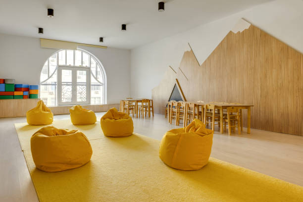 frijol amarillo bolsa sillas y mesas de madera en jardín de la infancia jugando sala - classroom education chair carpet fotografías e imágenes de stock