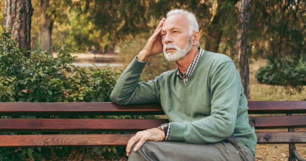 istock Senior man sitting on bench in the park 1062093468