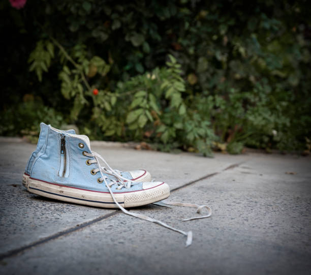 istock pair of old worn blue textile sneakers on gray asphalt 1062100152