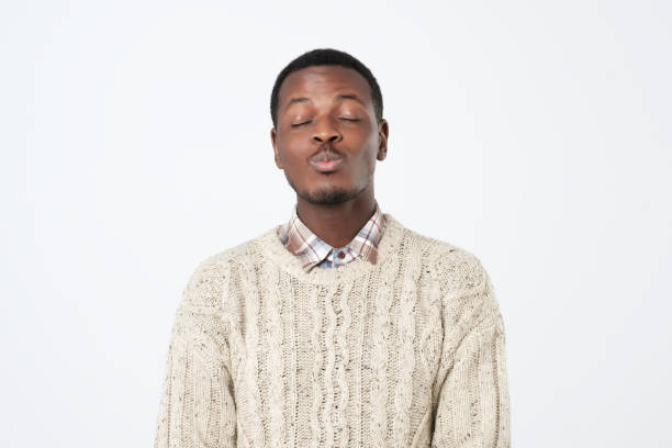 istock Young african man in sweater waiting for kiss. Isolated studio shoot. 1062101178