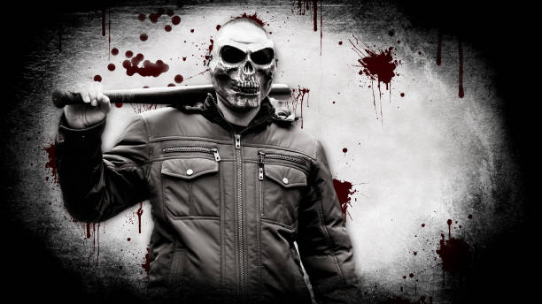 Bloody maniac in a mask with a baseball bat Brutal maniac in a mask in the form of a skull with a baseball bat against the background of the bloody wall serial killings photos stock pictures, royalty-free photos & images