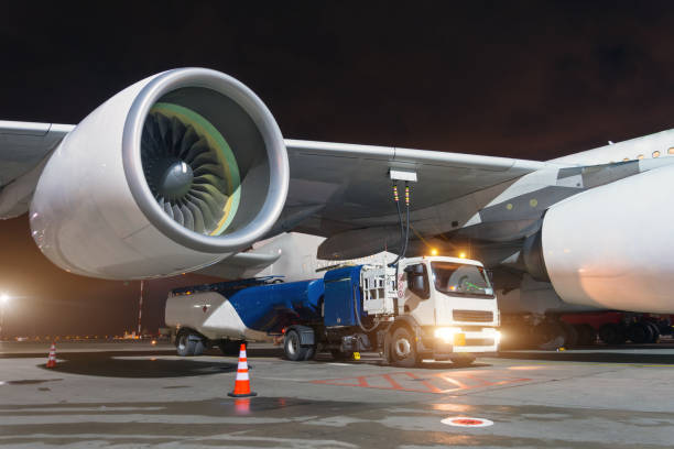 grandi motori a reazione per aerei, alimentando un enorme aereo, un camion con carburante con tubi collegati a un serbatoio del carburante. - biofuel foto e immagini stock