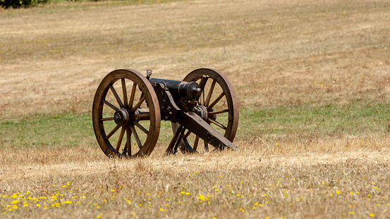 American Civil War small cannon on the grass, viewed from the back and side and plenty of copyspace