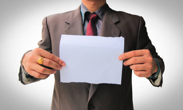 istock Businessman in suit showing white blank paper 1062110758