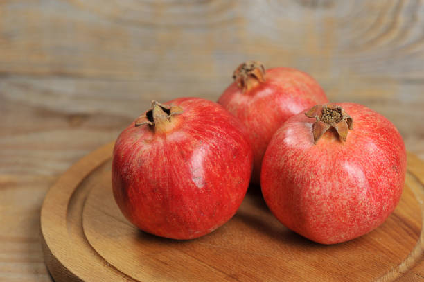 istock red pomegranates on a wooden background 1062122482