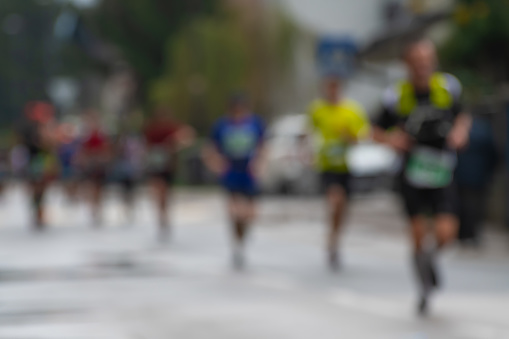 A group of marathon racers running on a rainy day