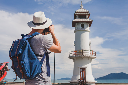Tourist photographer taking photo of lighthouse.