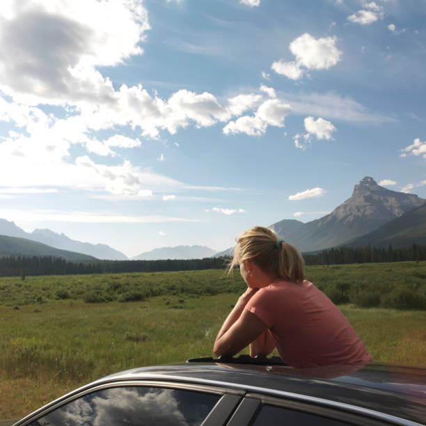 istock woman car meadow sunrise 1062129892